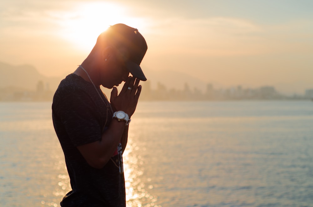 silhouette photo of man in black crew-neck shirt during golden hour