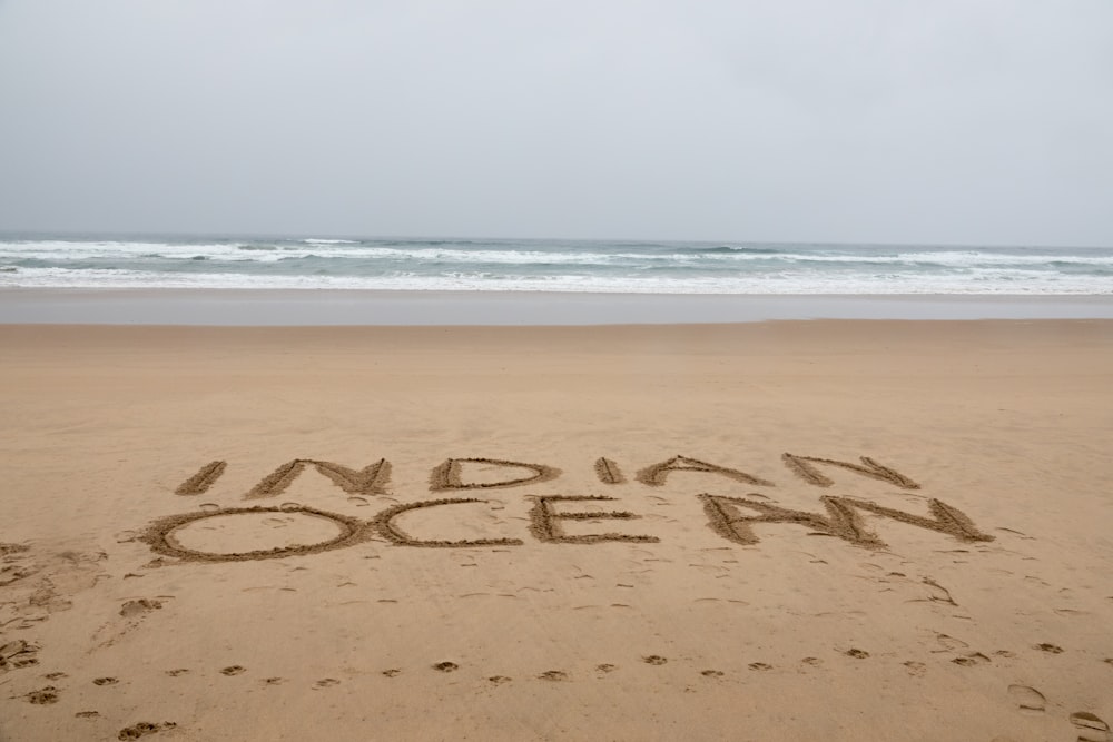 Indian Ocean word on brown sand beach