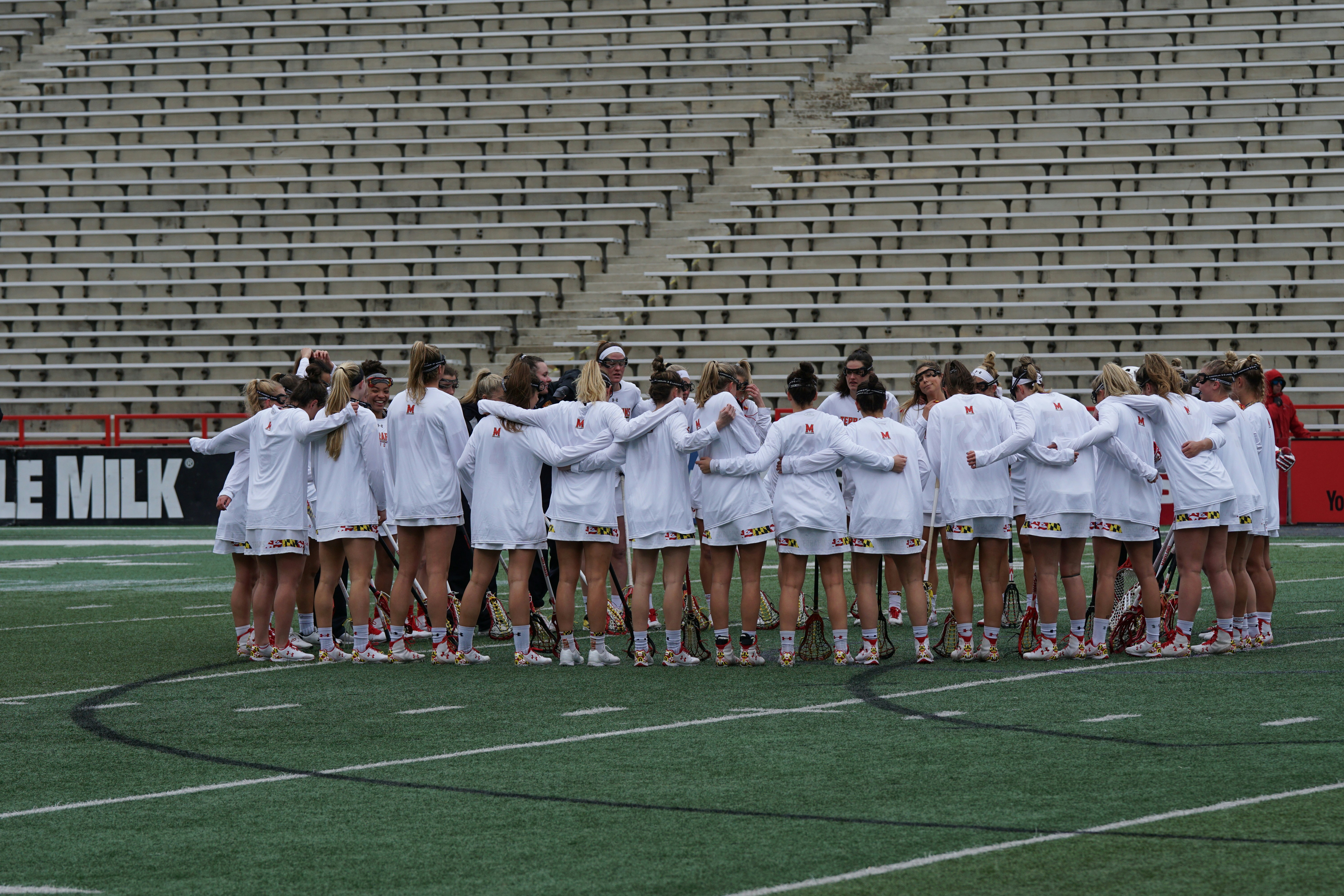 women wearing white long-sleeved shirt huddling outside