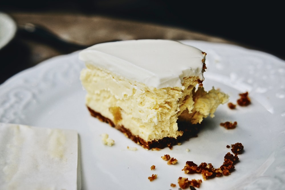 bitten slice of cake with cream toppings