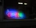 Close-up of a colorful LED sign illuminating a café entrance during evening hours.
