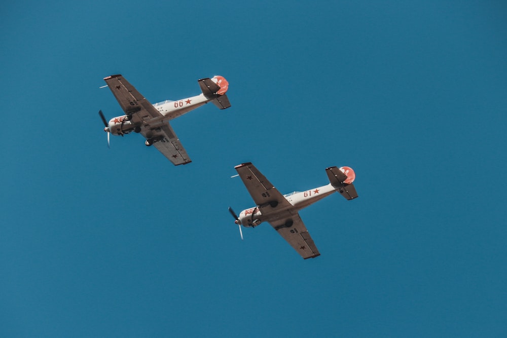 white and orange biplanes