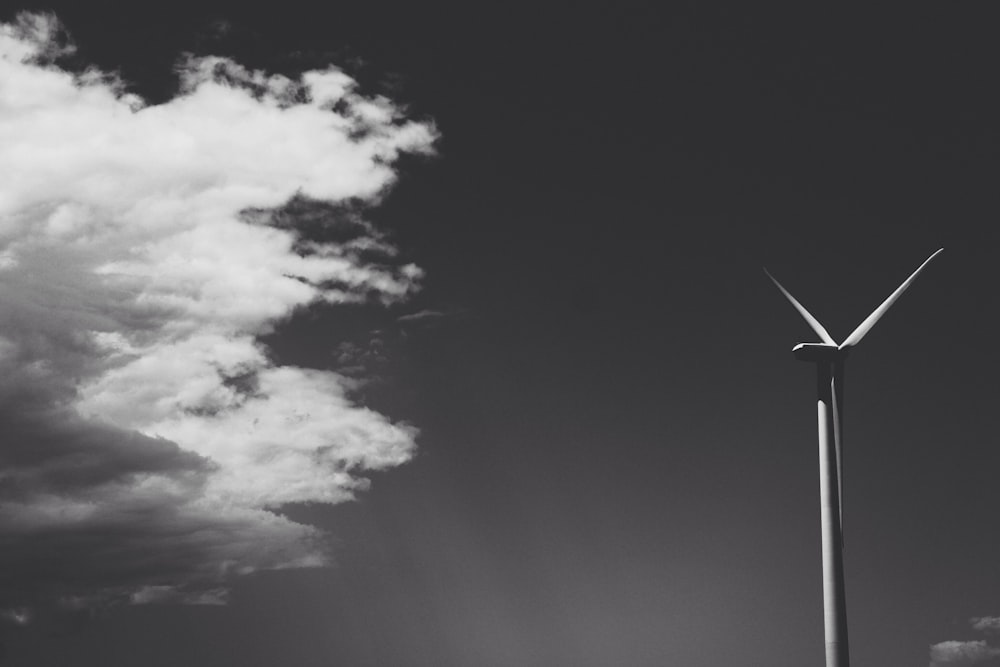 greyscale photo of windmill under cloudy sky
