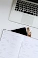 white book near Macbook Pro laptop