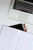 white book near Macbook Pro laptop