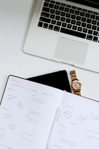 white book near Macbook Pro laptop