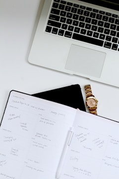 white book near Macbook Pro laptop