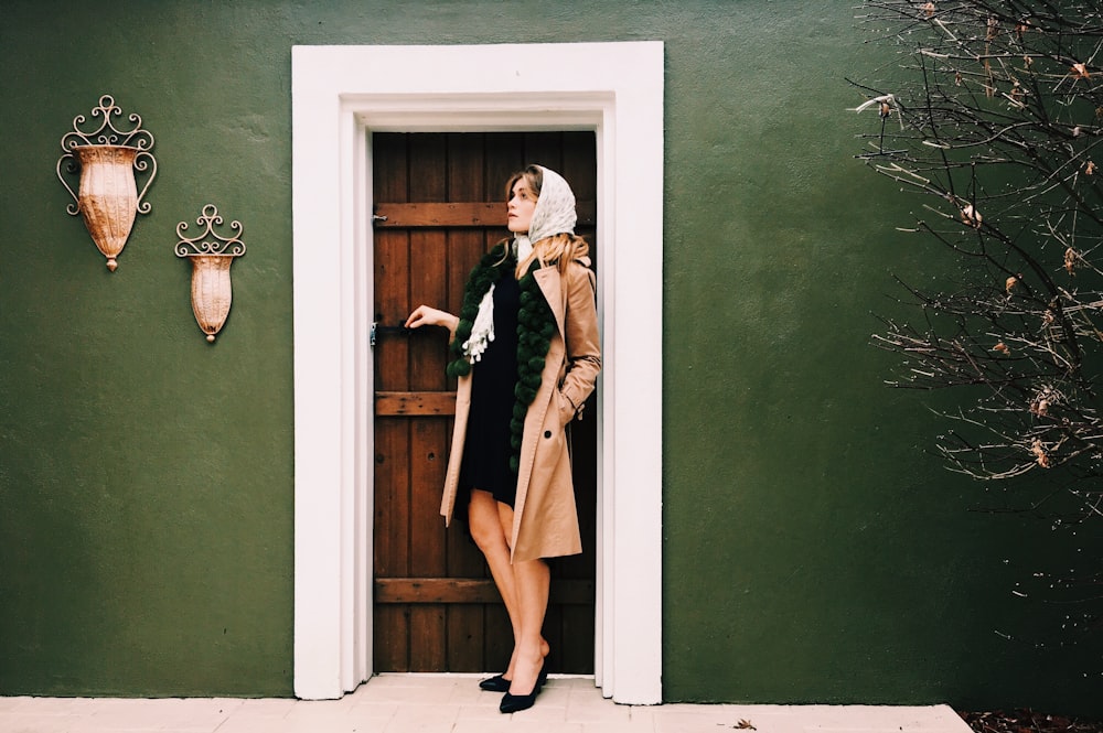 woman standing beside door during daytime