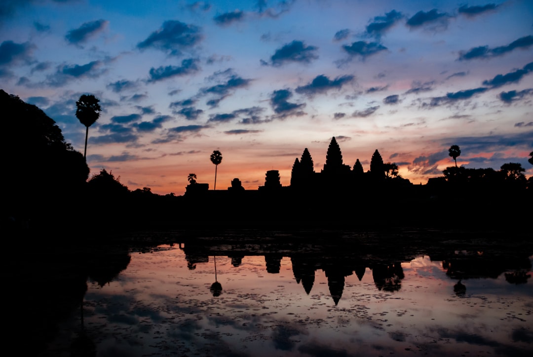silhouette of building under cloudy sky during golden hour,