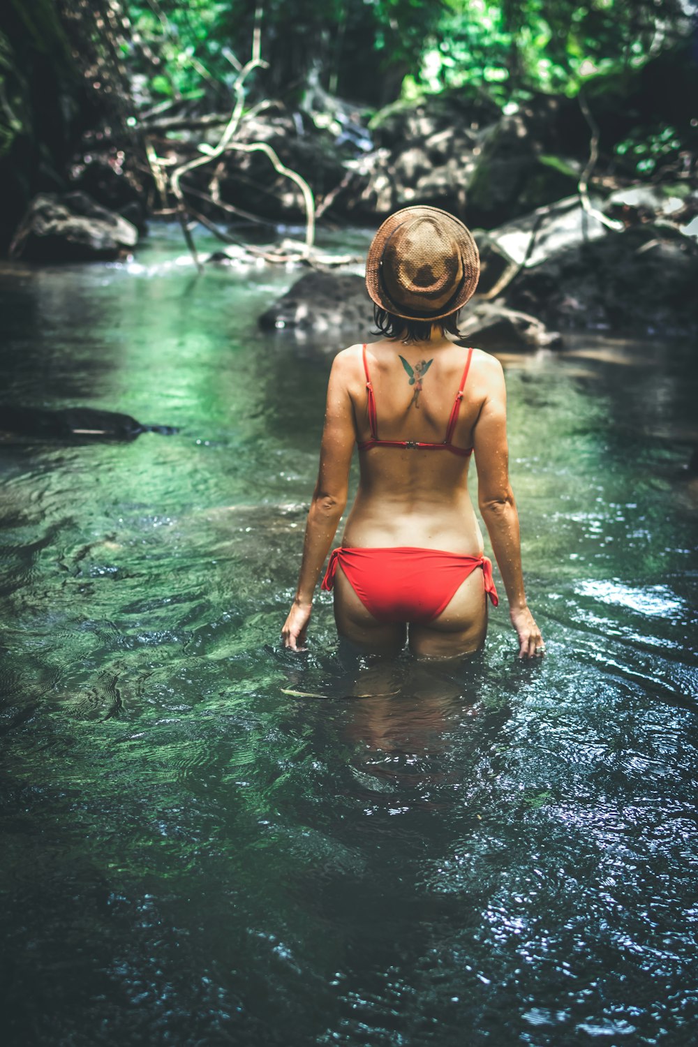 woman wearing black bikini on body of water