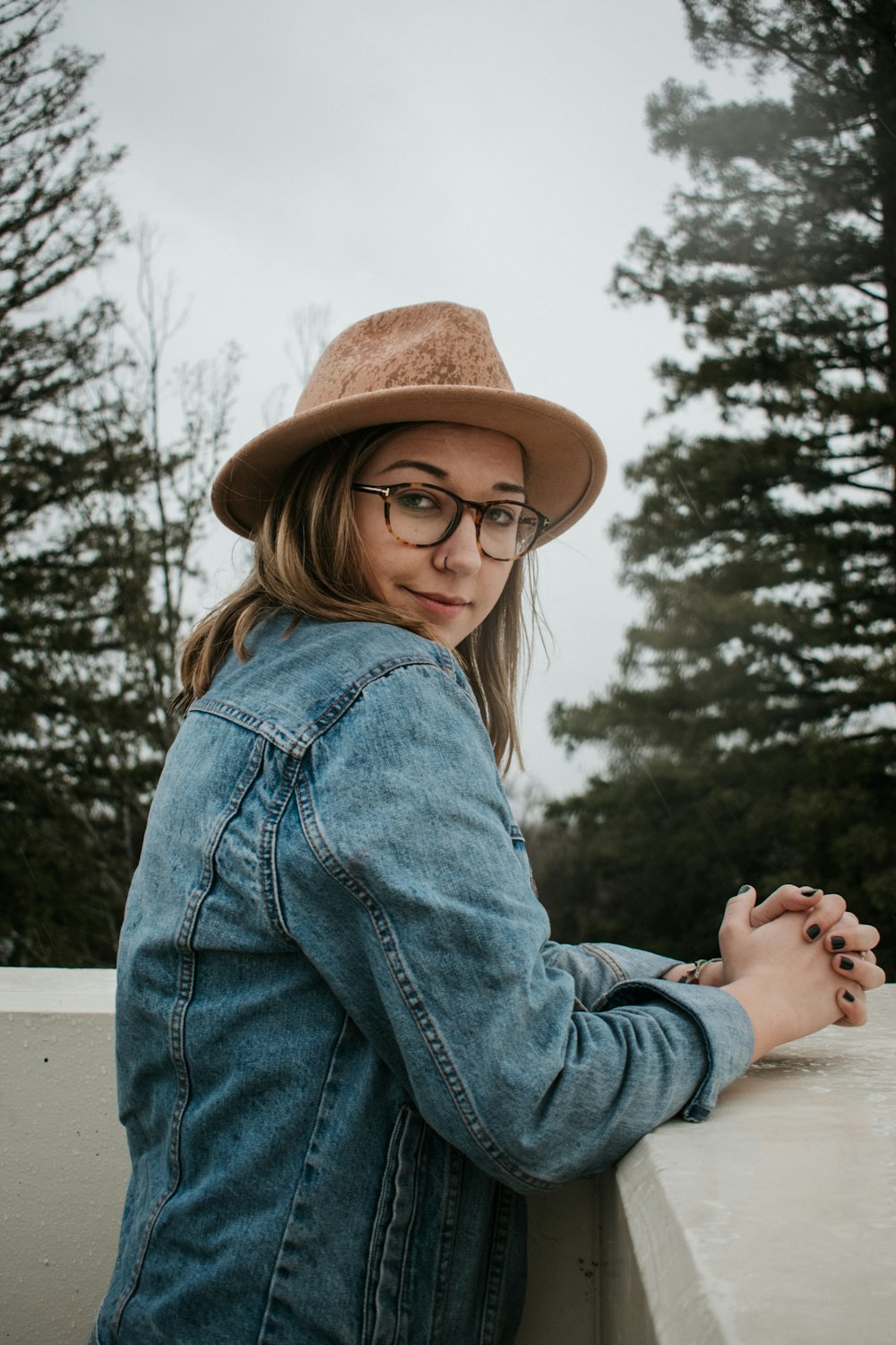 woman wearing blue denim jacket and black framed eyeglasses