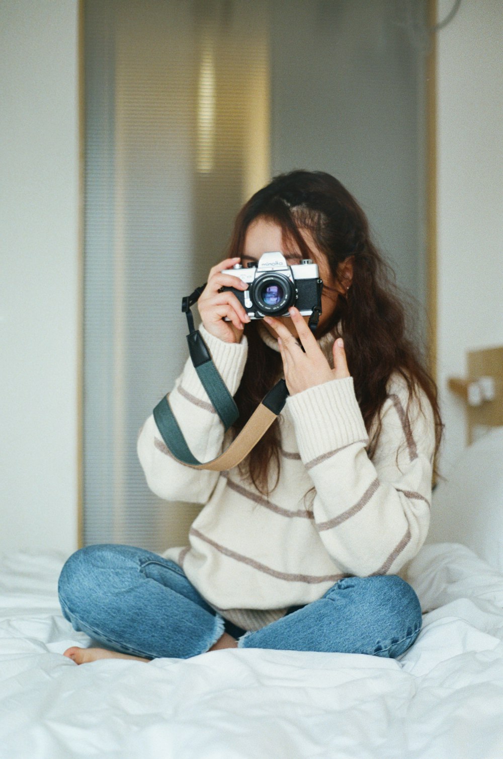 Mujer sosteniendo una cámara fotográfica profesional Foto de stock  1900020502