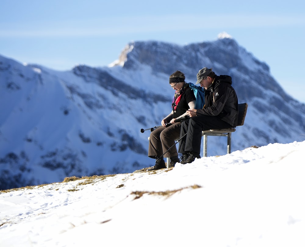 man sitting beside woman at bench