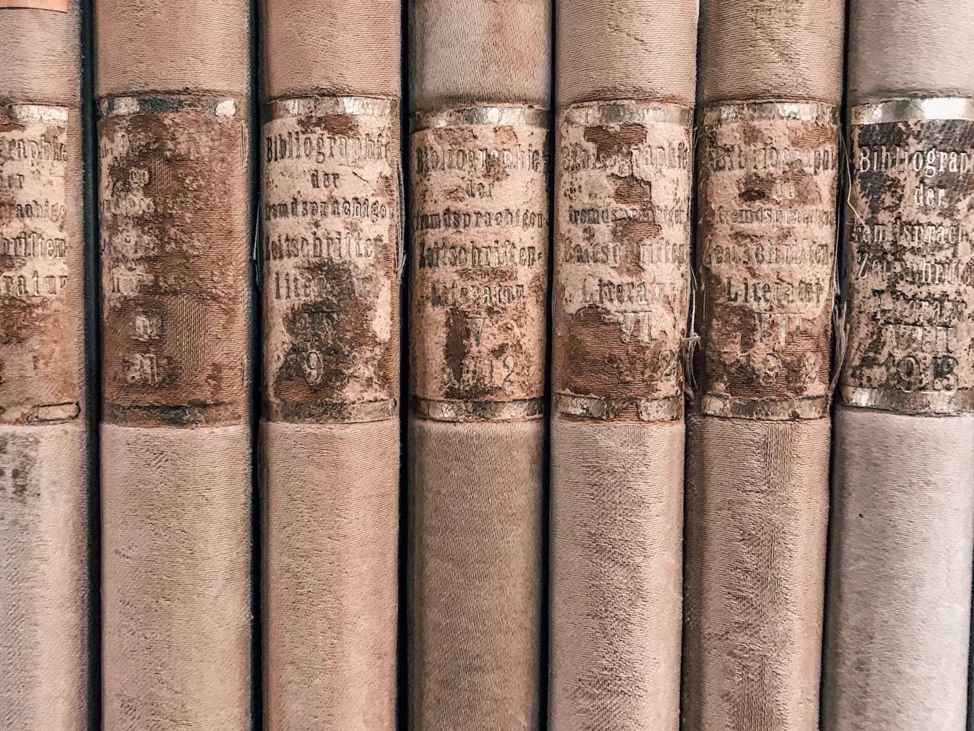 close-up photo of seven brown vintage books
