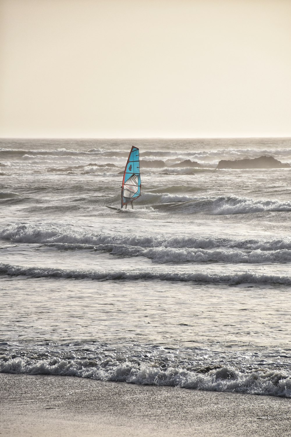 person playing sail boat on beach waves