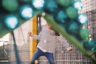 girl wearing white and black striped long-sleeved shirt playing in playground during daytime
