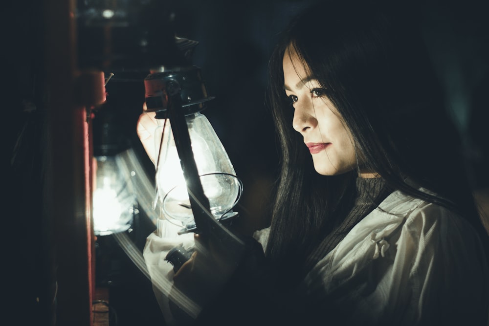 woman standing beside turned-on lamps