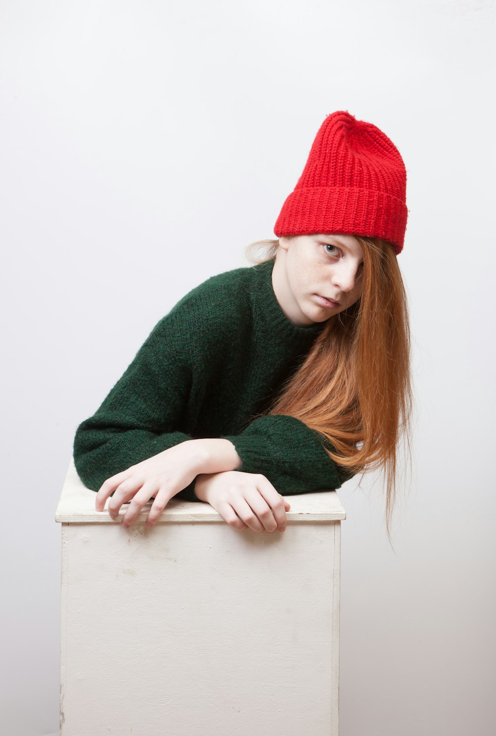 woman in green sweater and red beanie hat