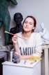 woman leaning on table and holding paint brush