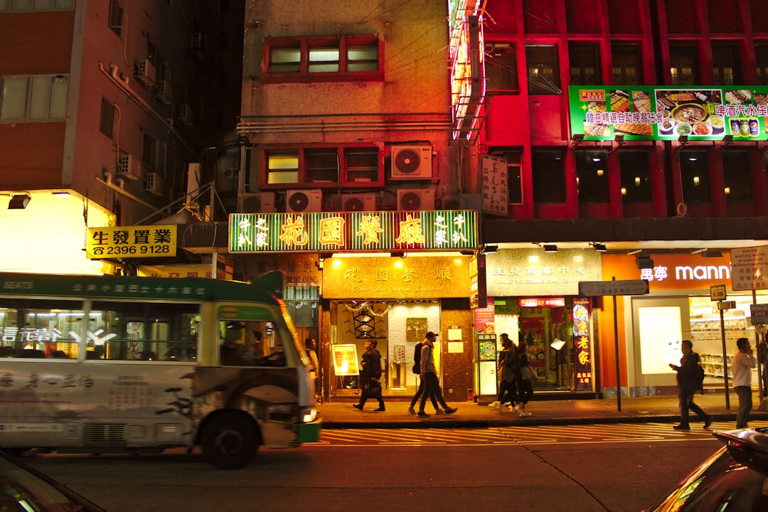 bus passing through building during nighttime