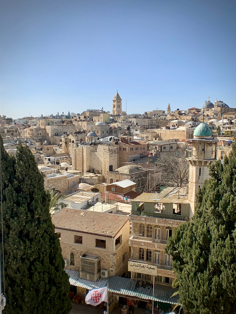 A vibrant view of Mardin's historic stone buildings under a clear blue sky, showcasing the city's unique architecture.