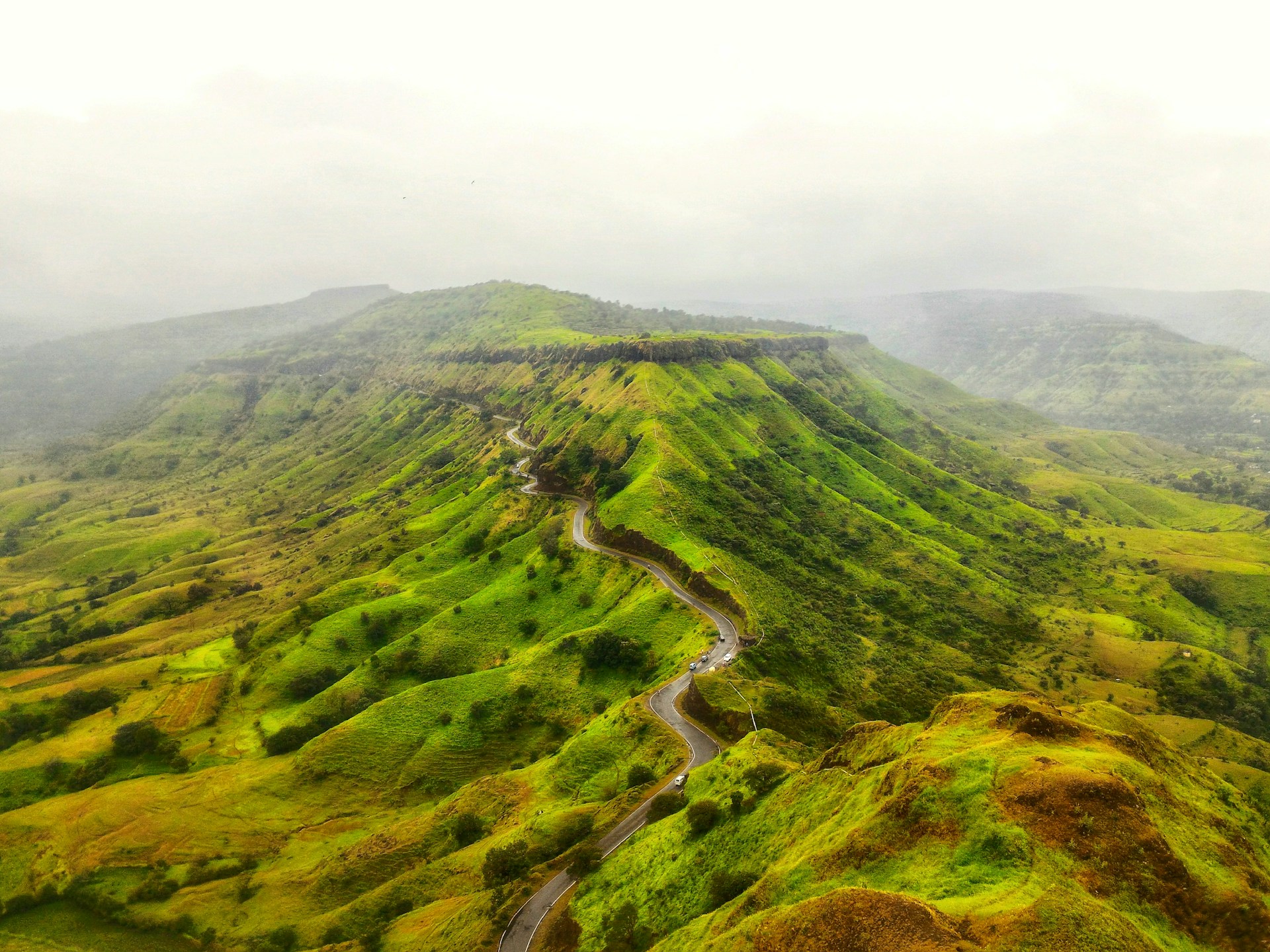 aerial photo of winding road near mountain