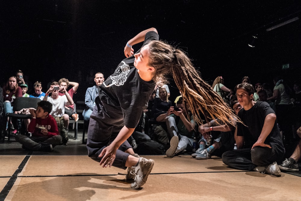 woman dancing in front of people sitting on floor