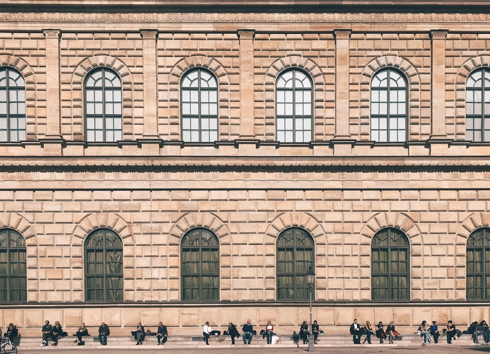 people sitting near the building during daytime