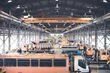 Modern construction machinery arranged neatly in a bright workshop space.