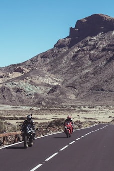 A scenic view of adventure motorcyclists riding through rugged terrain.