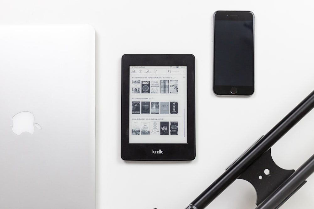 Lector de libros electrónicos Amazon Kindle negro sobre superficie blanca