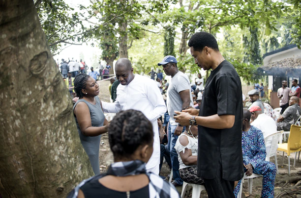 A group of diverse individuals engaged in a lively mentorship session outdoors.