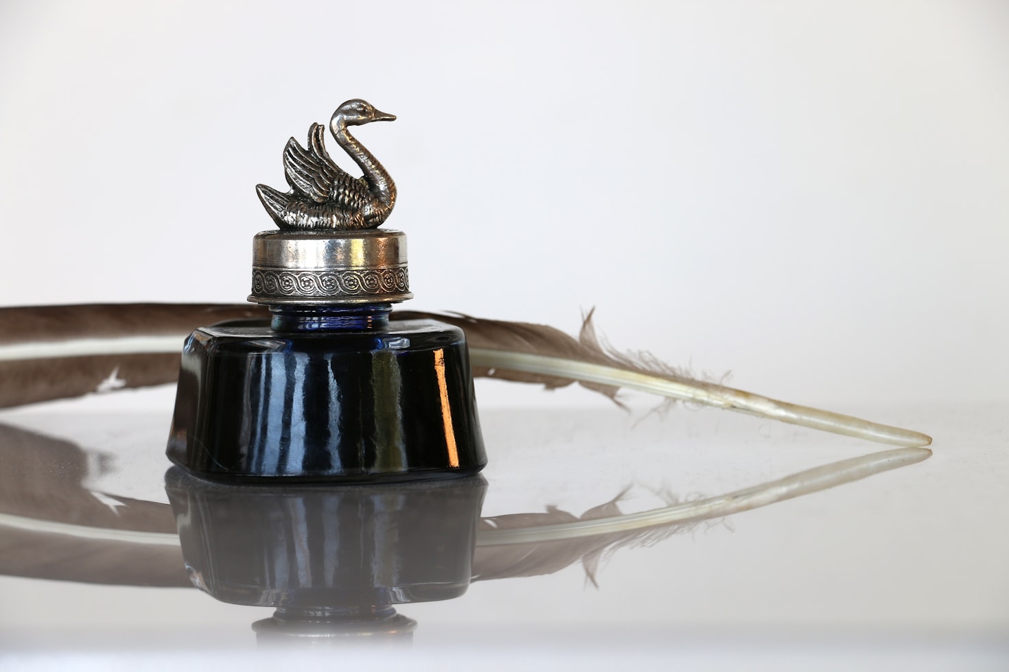 Image shows a quill with an inkwell