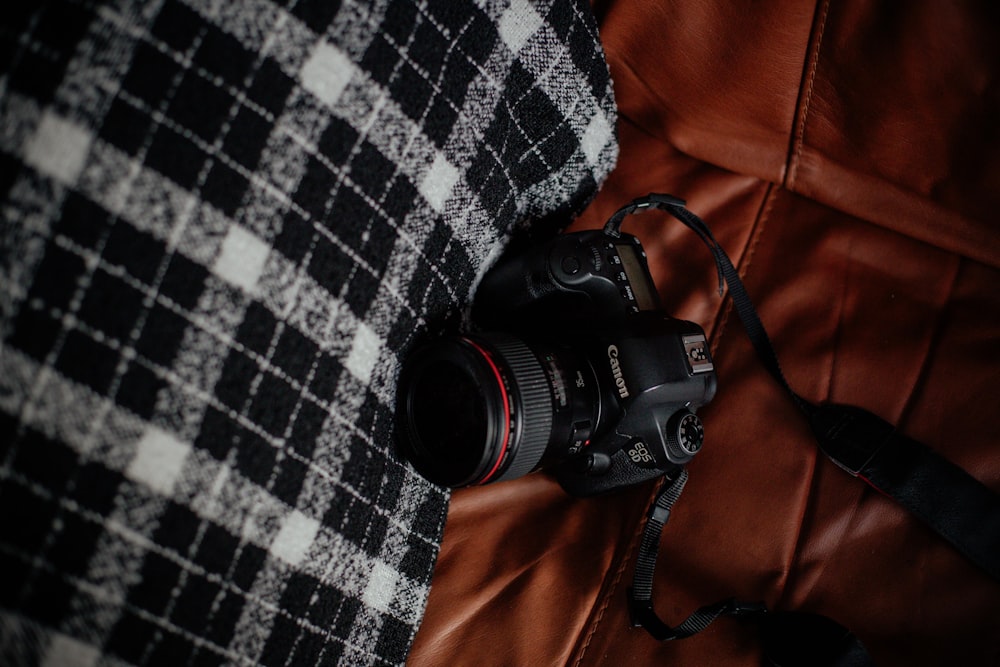 schwarze Canon Spiegelreflexkamera auf braunem Textil