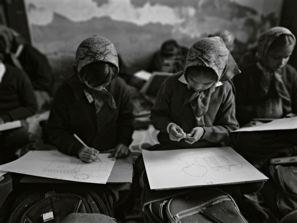 grayscale photography of children sketching