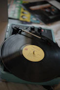 Vintage record player spinning a vinyl with album art featuring handwritten poem excerpts