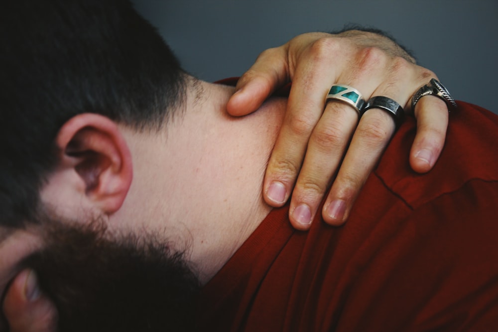 closed up photography of man wearing red crew-neck shirt