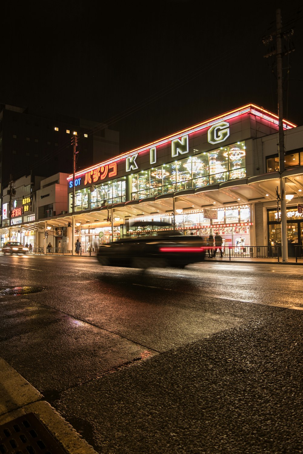 vehicles passing on road near buildings during nighttime