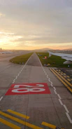 A freshly restored runway at dawn with a plane taxiing for takeoff.