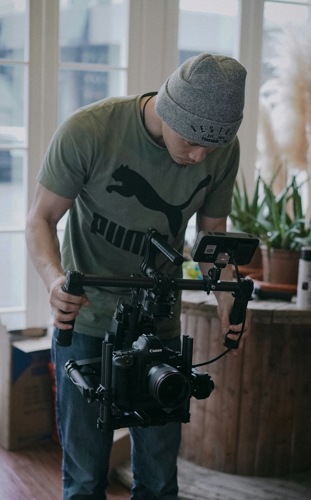 selective focus photography of man holding camera stabilizer