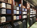 assorted-colored clothes on brown wooden shelf