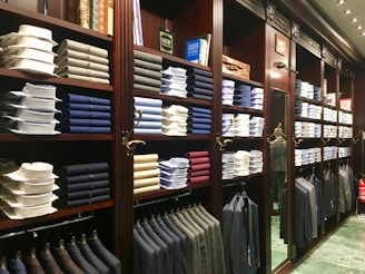 assorted-colored clothes on brown wooden shelf
