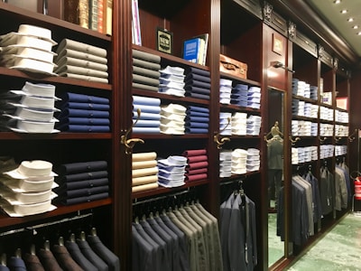 assorted-colored clothes on brown wooden shelf