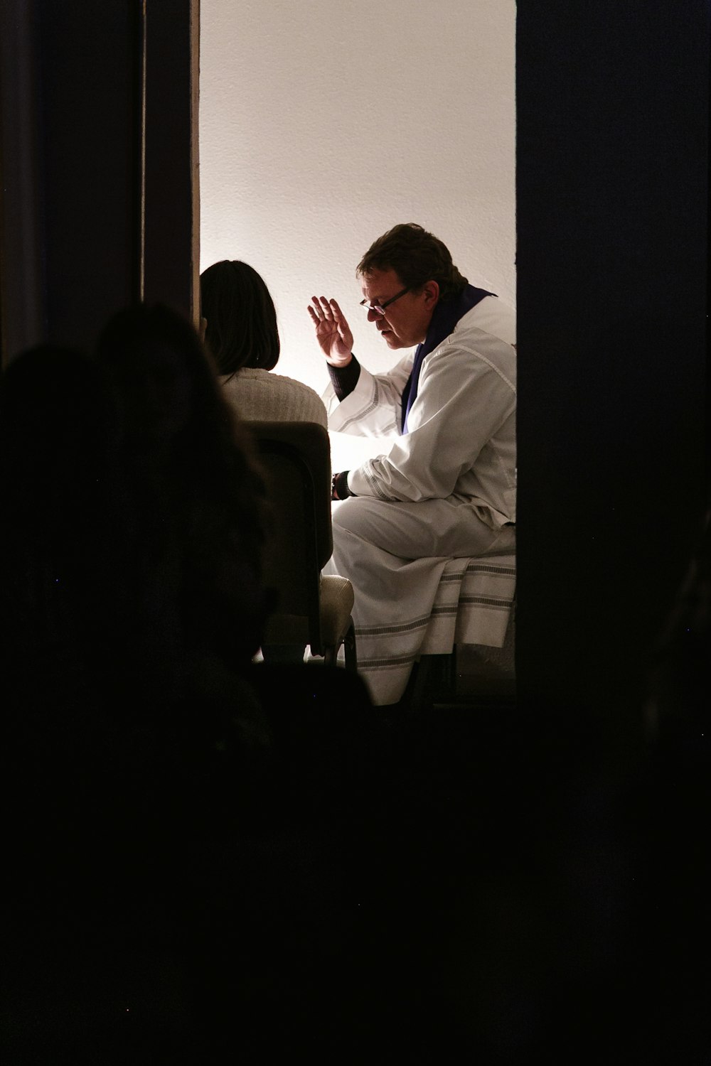 man wearing white bathrobe sitting on bed