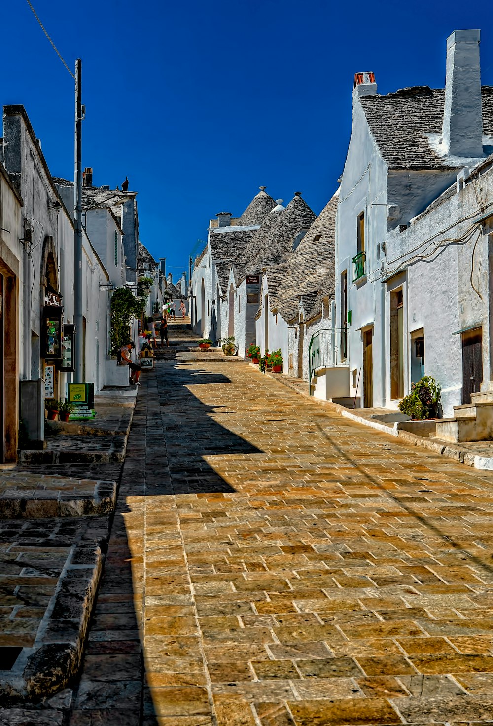 brown marble pathway between grey and white houses