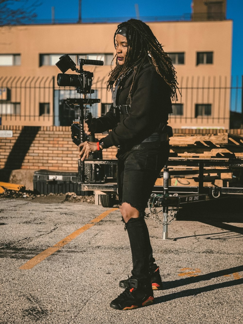 woman wearing black ripped jeans holding camera