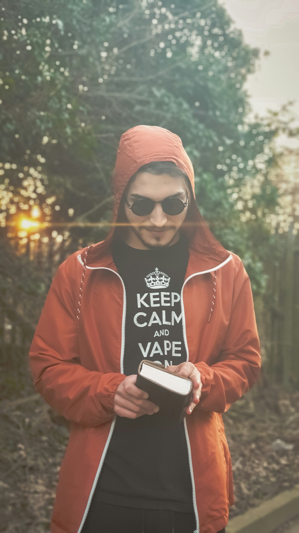 man in red hoodie holding book