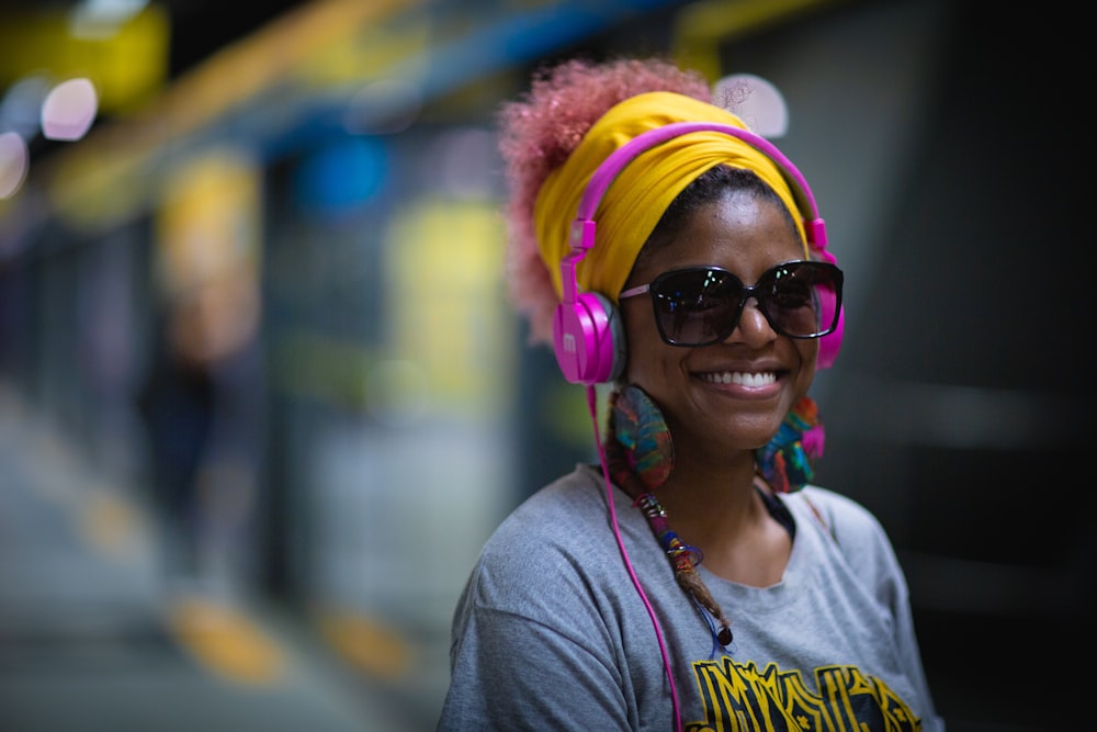 Lächelnde Frau mit Sonnenbrille in der Bahnhofsfotografie mit selektivem Fokus