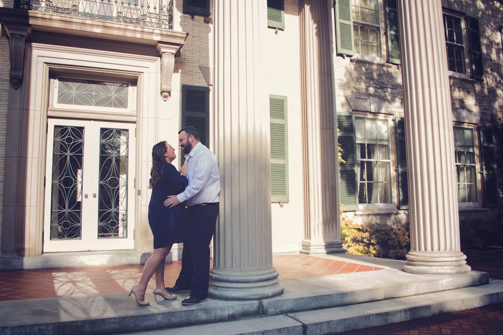 couple beside building pedestal