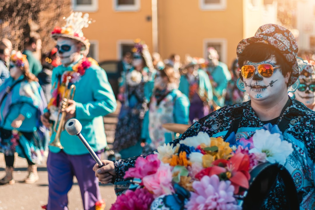 man sugar skull face painting while holding trumpet walking on street during daytime